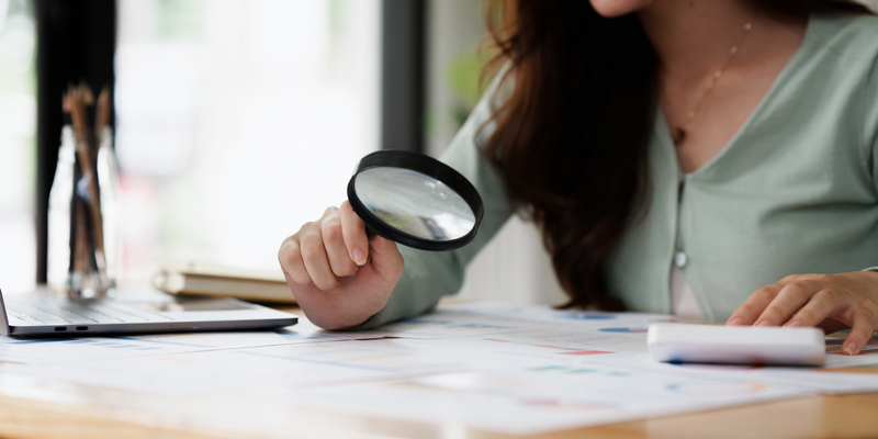 femme qui tient une loupe pour analyser