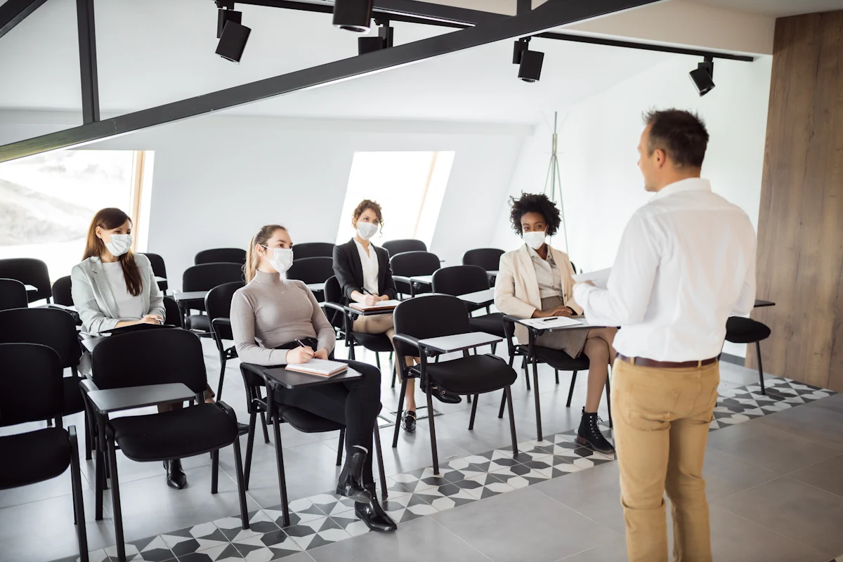 Plusieurs personnes assises qui écoutent une personne debout