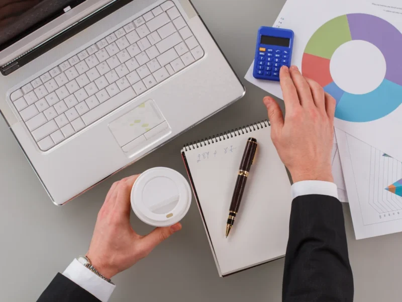 un homme devant son ordinateur qui fait des calculs