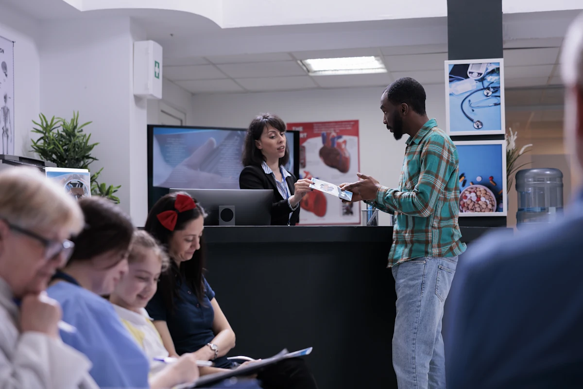 Une femme qui tend un document à un homme à l'acceuil